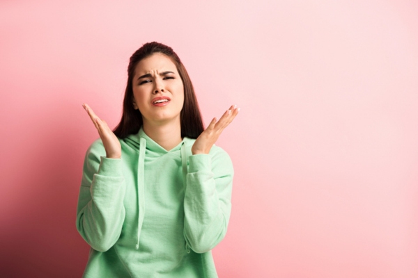 woman with arms open while shrugging depicting why water in an oil tank occurs