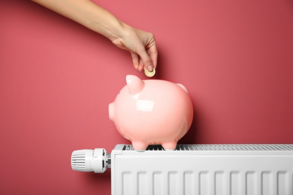 piggy bank on top of an oil-heat radiator depicting heating oil cost