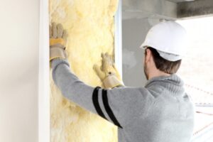 worker installing wall insulation