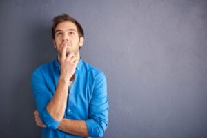 man looking up while thinking depicting Choosing The Right Heating System Size