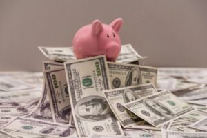 piggy bank on top of dollar bank notes depicting saving money