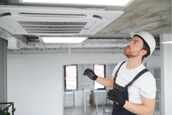 HVAC technician installing centralized air conditioner