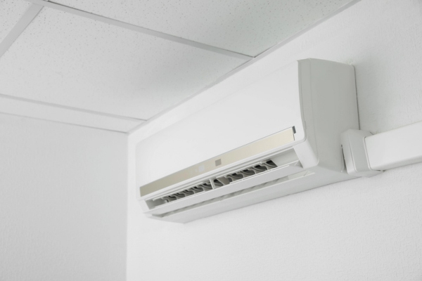 Modern air conditioner on white wall indoors