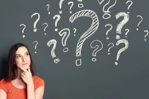 woman looking at question mark doodles on a chalkboard depicting FAQs About Air Conditioner Replacement