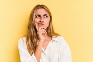 woman thinking looking up with hand on chin depicting How To Tell If Your HVAC Blower Motor Is Going Bad
