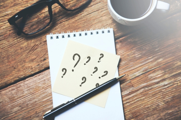 question marks on a sticky note on a notepad depicting Comfort Air Conditioner FAQs
