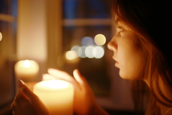 woman holding a burning candle depicting power outage