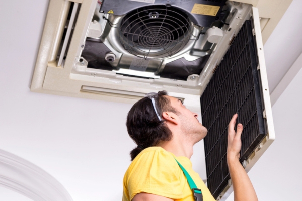 HVAC technician performing Routine Cooling System Maintenance