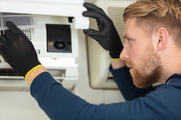 HVAC technician performing air conditioner inspection