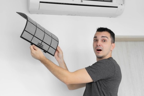 HVAC technician removing ductless AC filter
