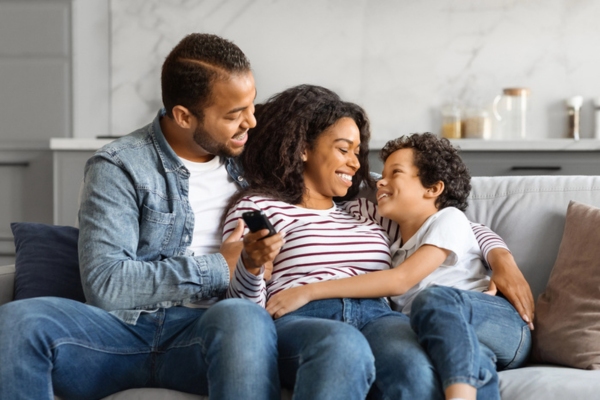 family lounging happily on their living room depicting air conditioning safety