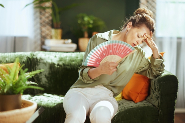 woman feeling warm indoor due to air conditioner not working properly