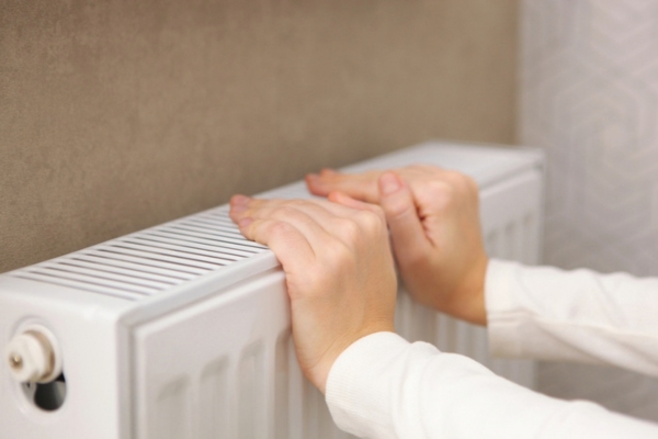 girls hands checks for heat from radiator
